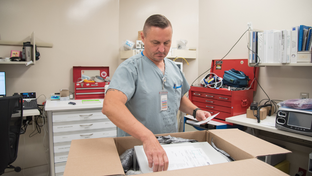 technologist unpacks a box