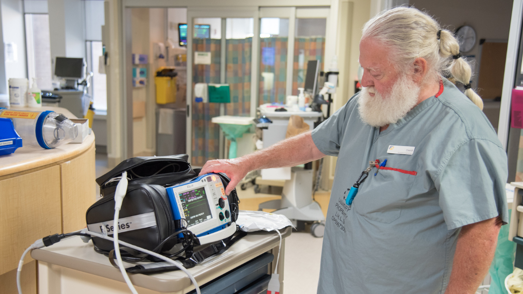 technologist works on defibrillator