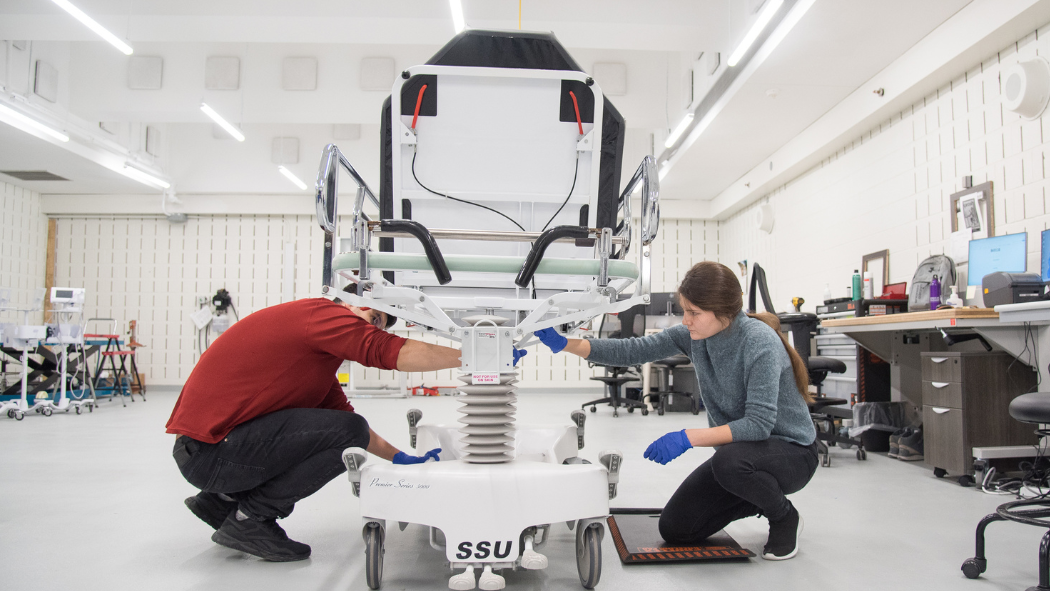 technicians work on patient stretcher