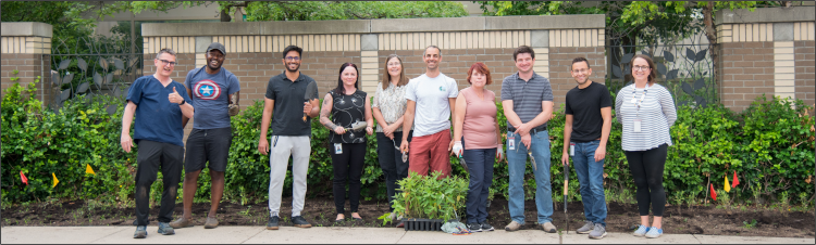 LHSC Green Team members smiling for photo in front of the new pollinator garden area.
