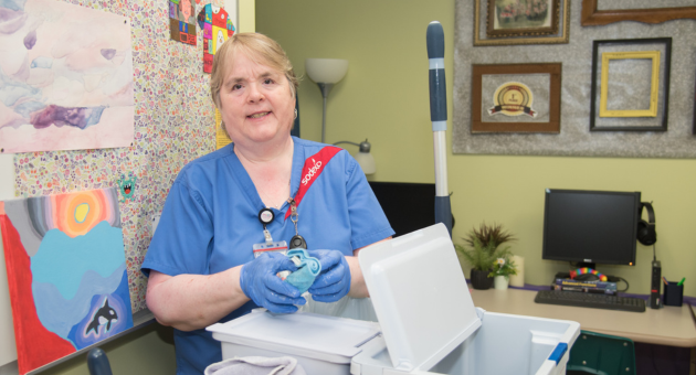 Housekeeper stands behind cleaning cart