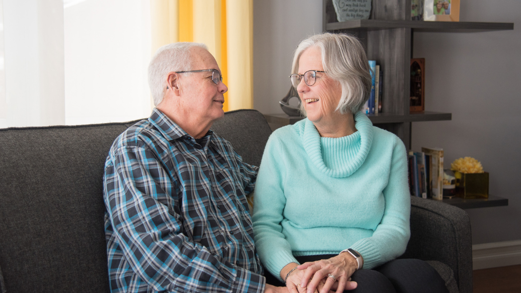 Bonnie Field and her husband, Gord, sitting on a couch