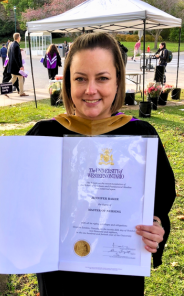 Jen Baker holding her Masters degree
