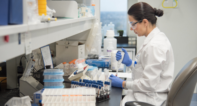 Medical laboratory technologist using a pipet in lab