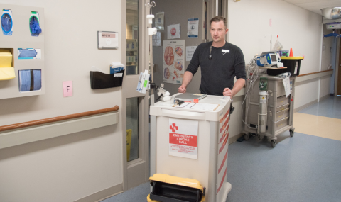 Stroke Unit Nurse pushing stroke cart down hallway of hospital