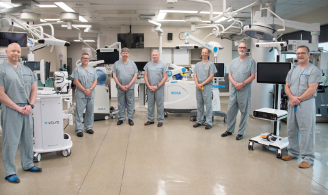 LHSC Surgeons standing around 4 ortho robots used for surgery