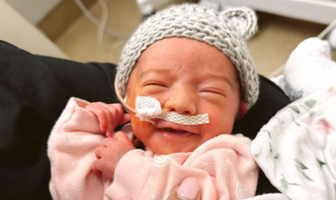 Ivy Spooner's mother, Emily, holds her in the NICU